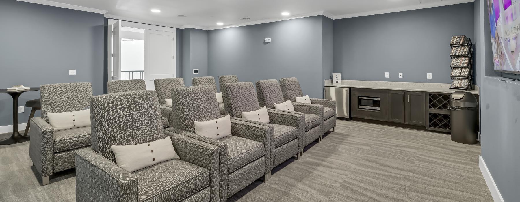 a room with a couch and chairs and a tv screen