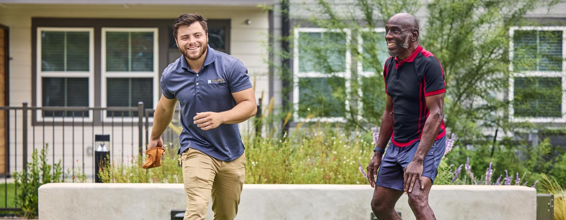 a couple of men playing cornhole